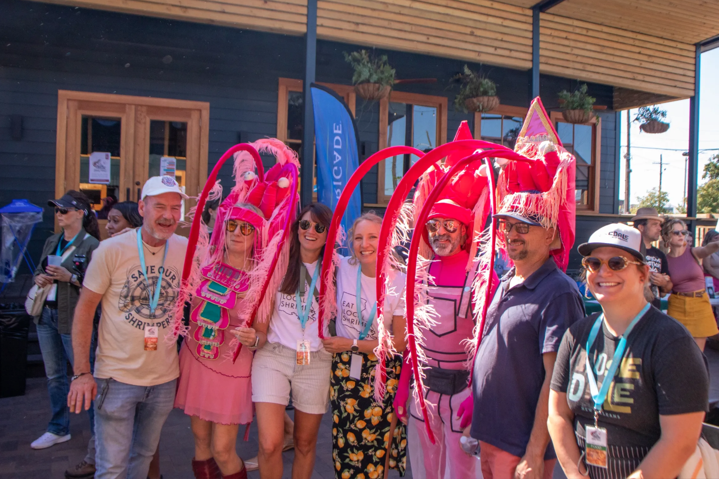 Chef Dana Honn (far left) and other festival-goers dressed in pink shrimp costumes smile together at the Louisiana Shrimp Festival and Shrimp Aid
